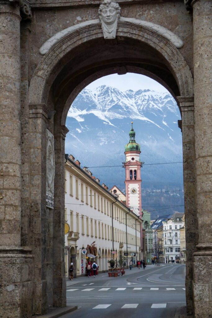 Eerste keer op wintersport: mijn ervaring & tips | Oostenrijk, Praktische reistips Poort in Innsbruck met de bergen op de achtergrond